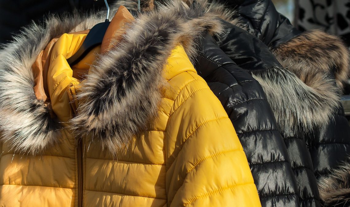 down jackets with fur-trimmed hoods on a rack